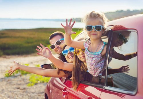 Portrait,Of,A,Smiling,Family,With,Two,Children,At,Beach Familie im Auto Urlaub 405066019 scaled 500x0 c default
