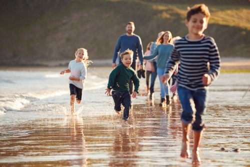 Children,Run,Ahead,As,Multi Generation,Family,Walk,Along,Shore,On