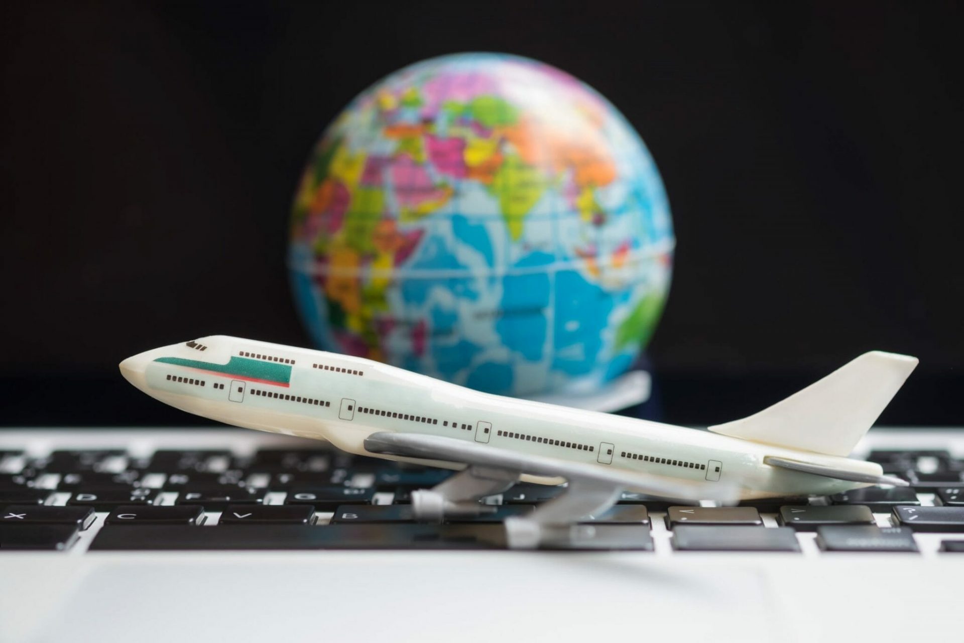 Travel,Concept.,Airplane,Model,Toy,On,Laptop,Computer,With,Mini