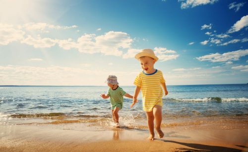 Boy,And,Girl,Playing,On,The,Beach,On,Summer,Holidays.