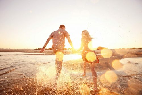 Happy,Couple,Running,On,The,Beach