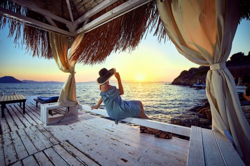 Woman,In,Hat,Relaxing,By,The,Sea,In,A,Luxurious